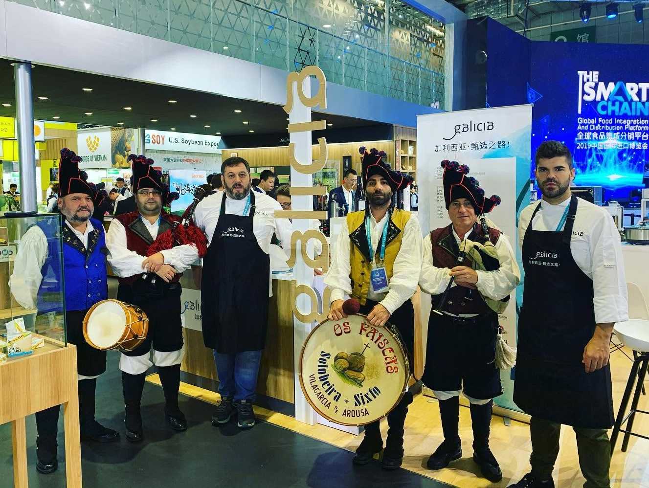 Miguel Mosteiro junto a unos gaiteiros gallegos en la feria ciie en China